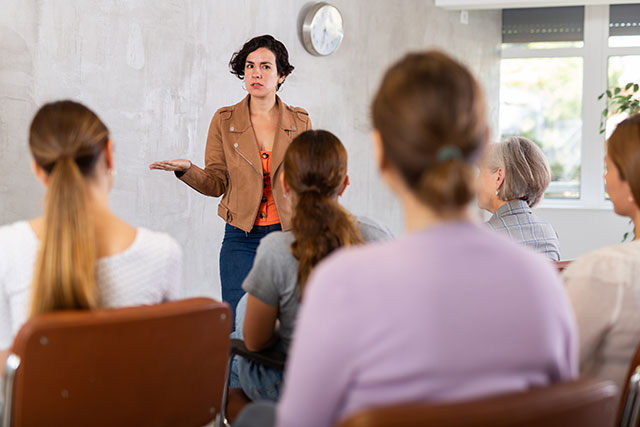Jonge vrouw presenteert voor een groep mensen